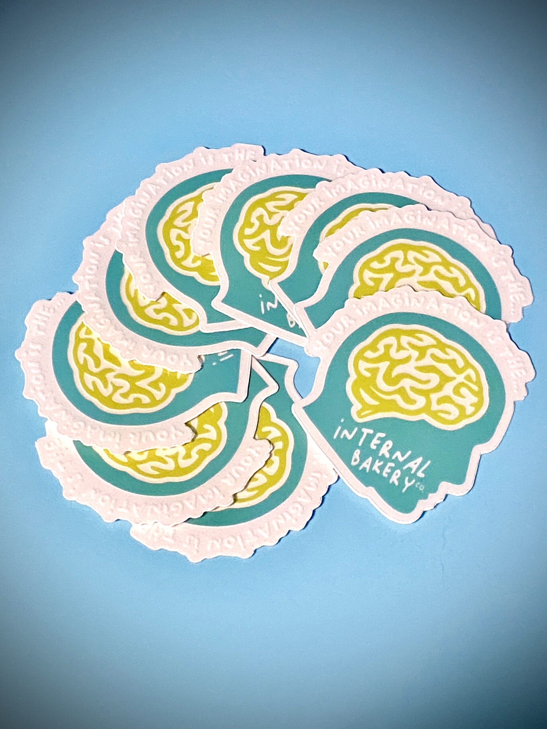 “Your Imagination Is The…” Clear Head Sticker (1.96″ × 2″) A peek inside the bakery of your mind 🍞💭 This trippy lil’ sticker puts your imagination on display — literally. The clear design lets your surroundings show through the brain and face, blending your world into the art itself. It’s a blue head, a chartreuse brain, and a reminder that the wildest ideas live upstairs. Stick it on your laptop, water bottle, or mirror — anywhere you wanna remember that your imagination is the Internal Bakery.