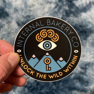 Internal Bakery Logo Sticker (3”) Unlock the Wild Within. This 3-inch sticker features the reimagined Internal Bakery logo — a symbol of imagination, curiosity, and the wild creative spirit that lives inside us all. Hand-drawn and designed in Colorado Springs, this mark represents the heart of our rebrand: Unlock the Wild Within. Stick it anywhere that needs a little spark — your water bottle, laptop, sketchbook, or car window — and let it remind you to keep creating, keep exploring, and keep seeing the world through your own wild lens. Durable, weatherproof, and made to last — just like your imagination.