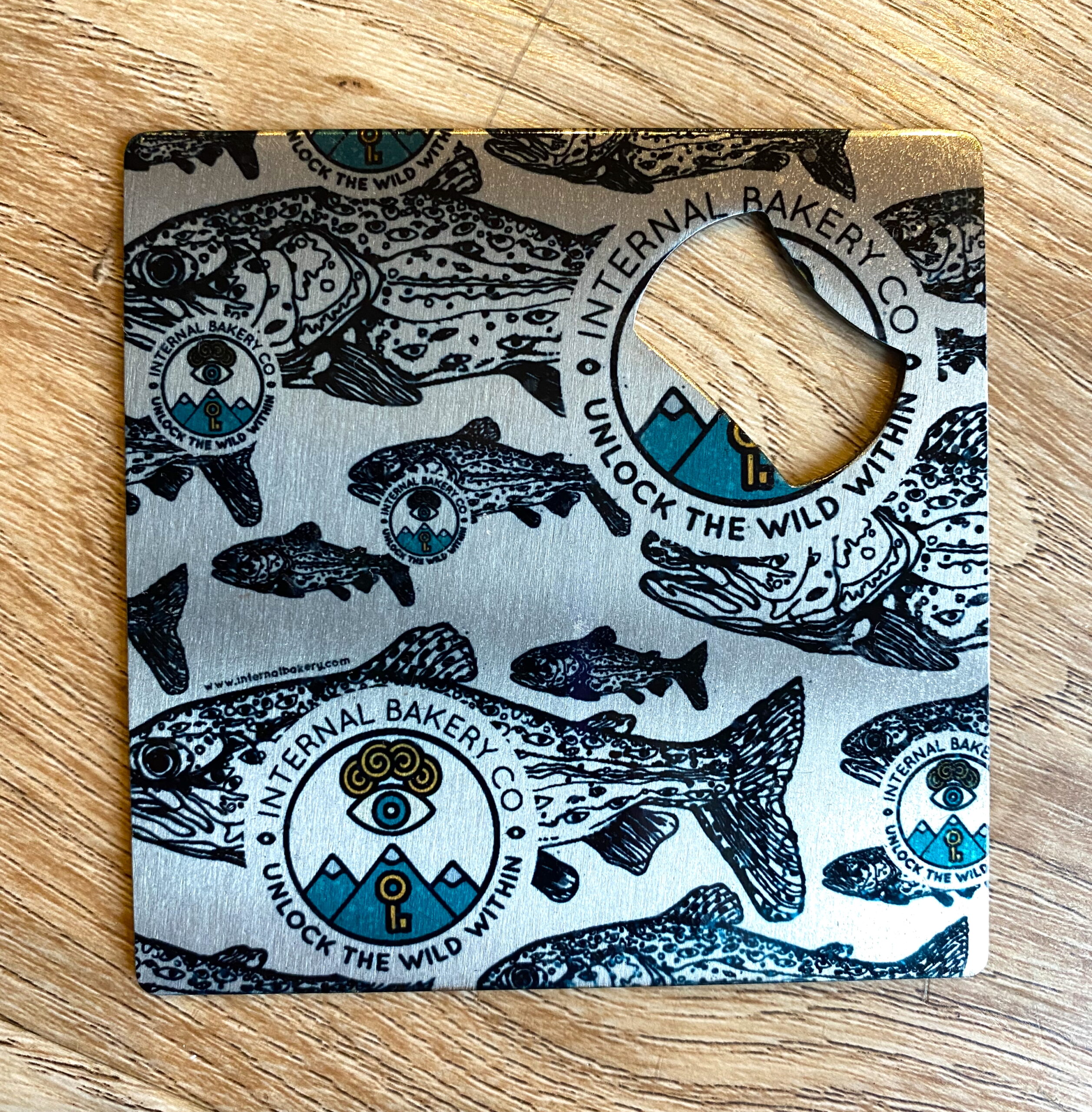 A real catch for your drinks! This compact 3.5" metal piece does double duty: open bottles effortlessly and protect surfaces as a coaster. Featuring the original Lookout Trout™ artwork in bold black outlines with a pop of Internal Bakery color, it’s functional, durable, and full of imaginative style. Small size, big personality—your drinks just got wilder.