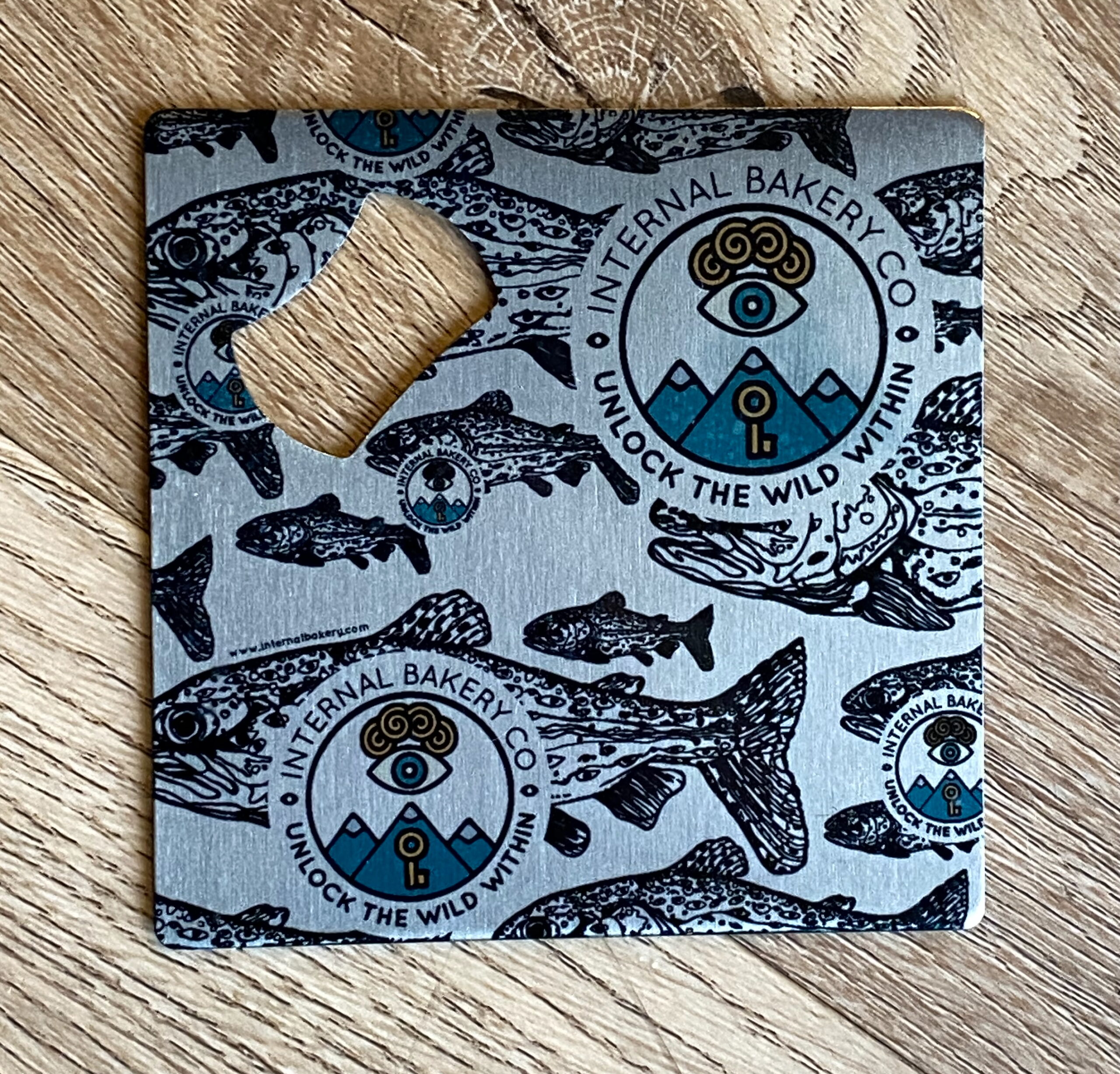 A real catch for your drinks! This compact 3.5" metal piece does double duty: open bottles effortlessly and protect surfaces as a coaster. Featuring the original Lookout Trout™ artwork in bold black outlines with a pop of Internal Bakery color, it’s functional, durable, and full of imaginative style. Small size, big personality—your drinks just got wilder.